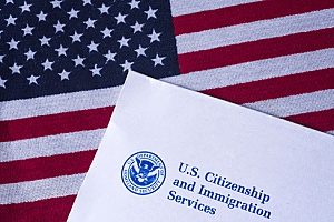 the USCIS logo on a paper resting on top of an American flag