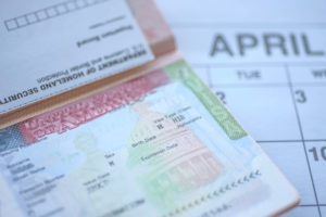 passport of a permanent labor certification recipient lays on top of calendar