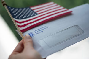 permanent labor certification applicant holds mail and flag