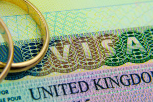 the tourist and fiance wedding rings sits on top of the visa