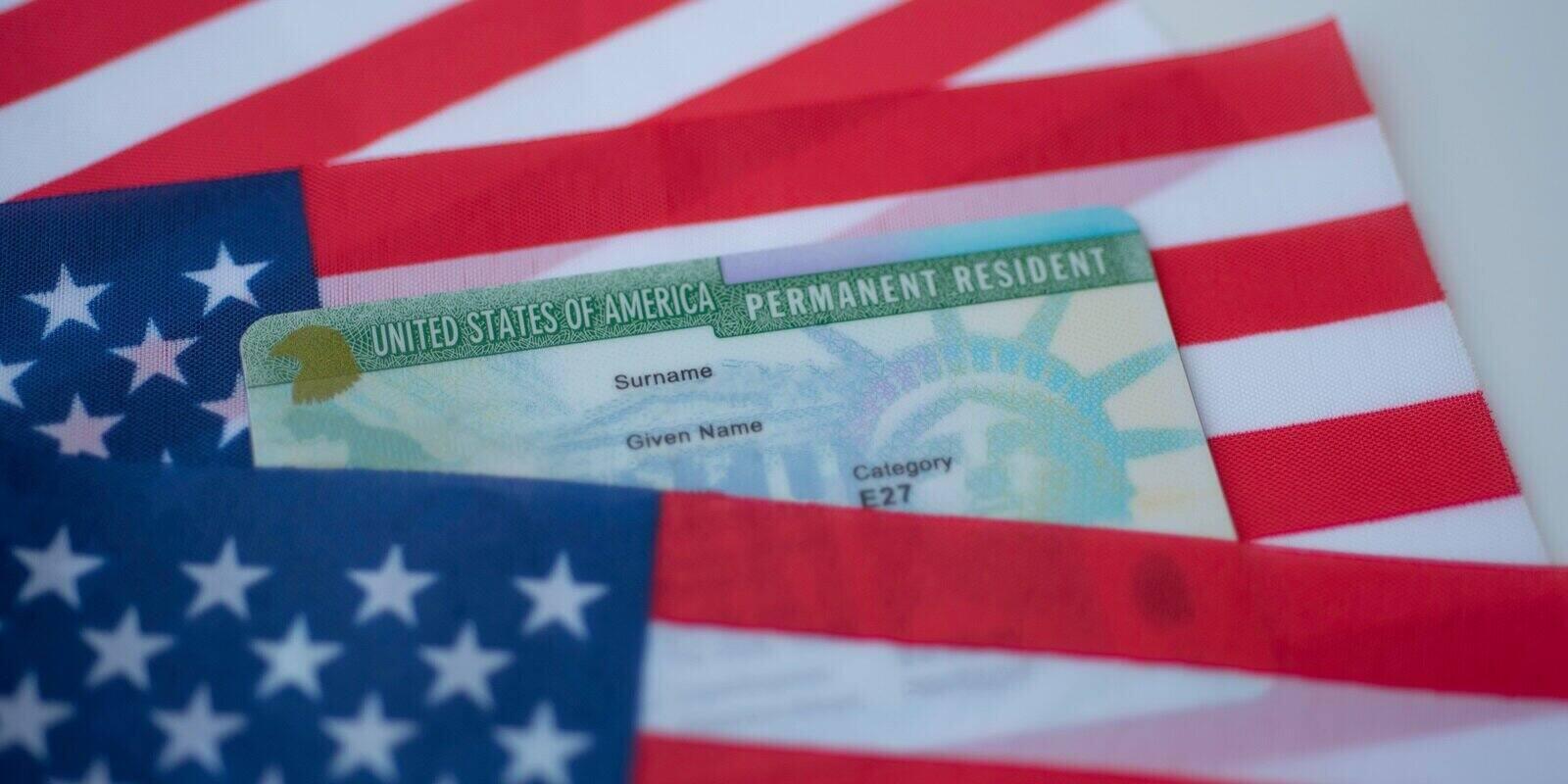 permanent resident green card of united states on flag of usa surface