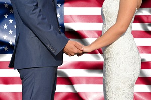 Woman and man getting married in front of the American flag