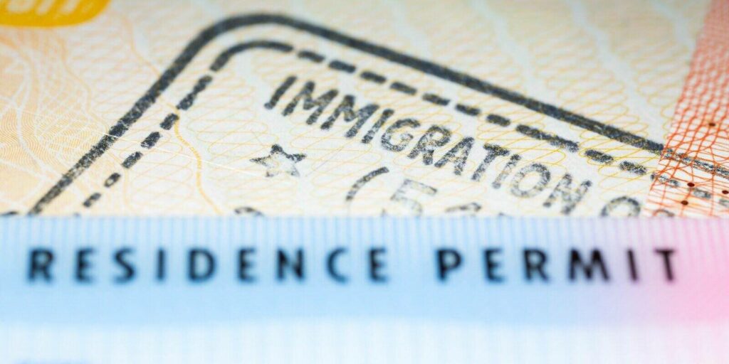 residence permit card over immigration stamp