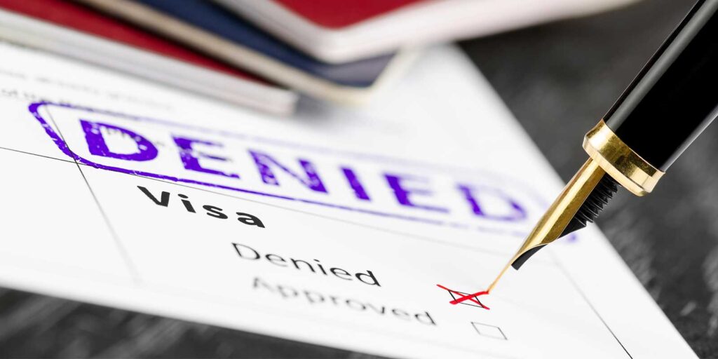 a red pen marking a visa application denied