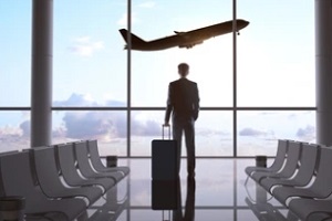 man holding bag looking at airplane