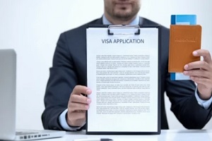 man holding visa application passport and flight ticket