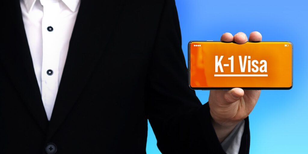 man holding k-1 visa text on phone