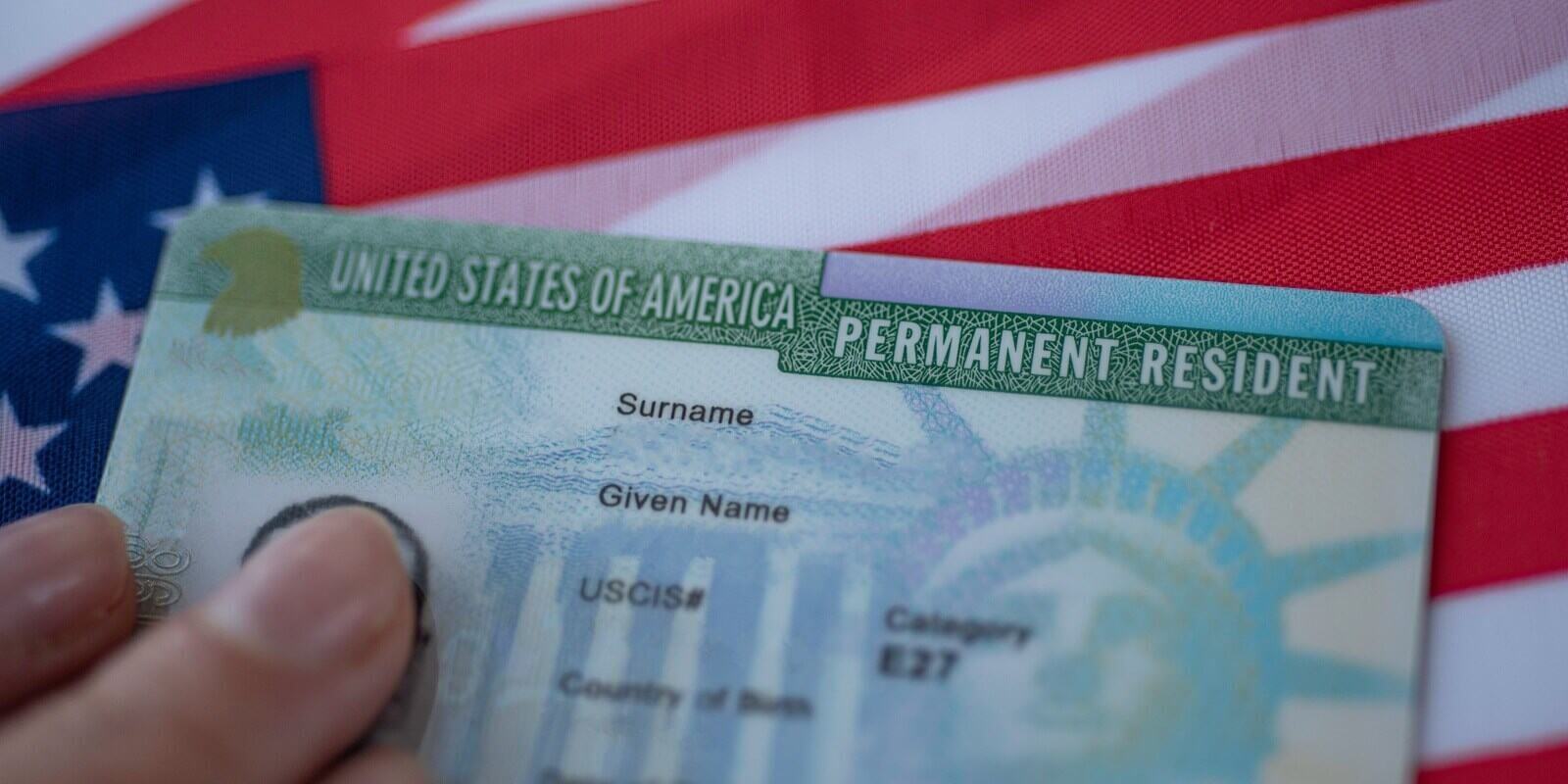 permanent resident green card of united states of america on flag of usa